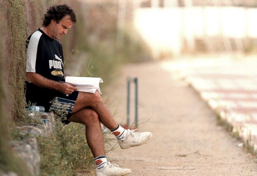 Un entrenador leyendo apuntes y notas de análisis