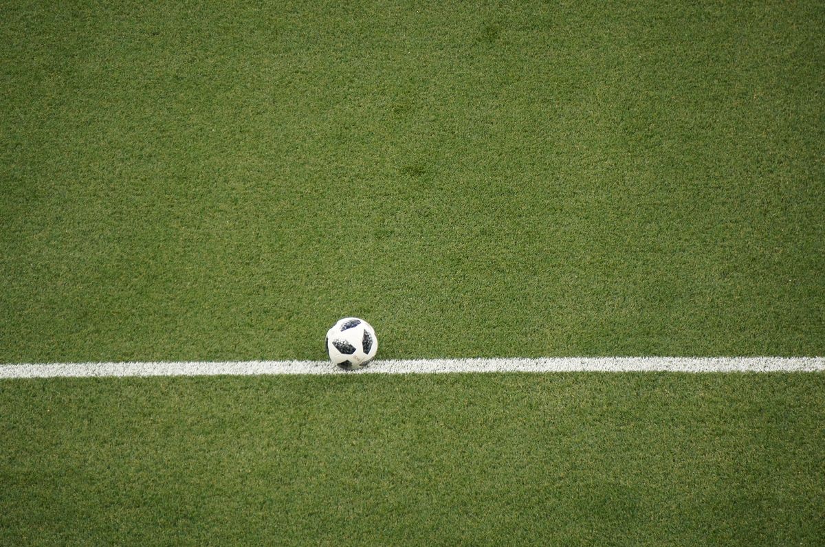 Pelota apoyada sobre la línea de cal de la cancha